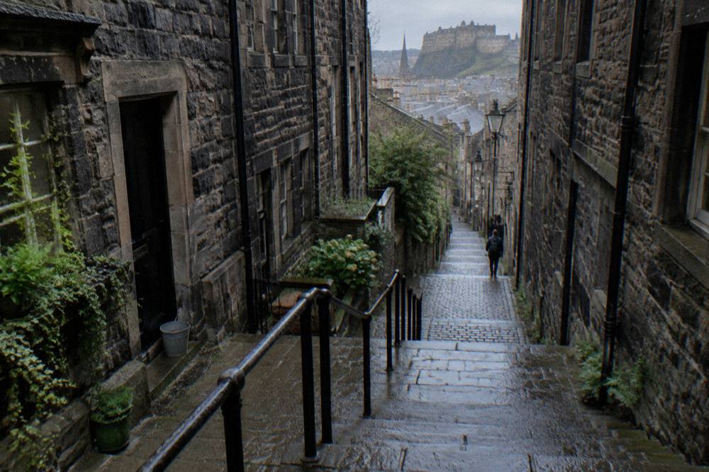 Cobbled close descending between tall stone tenement buildings in the Old Town