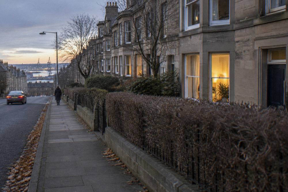 A quiet residential Edinburgh street with terraced houses in the evening