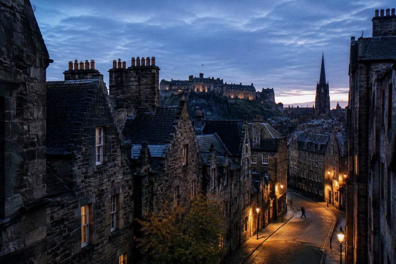 Edinburgh old town rooftops and a lit street in the early evening