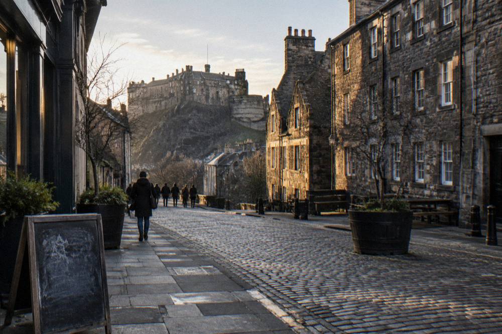 A quiet Edinburgh close in winter with warm window light on stone walls
