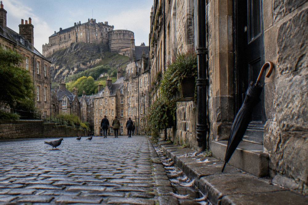 Cobbled Grassmarket street with Edinburgh Castle rising above the buildings