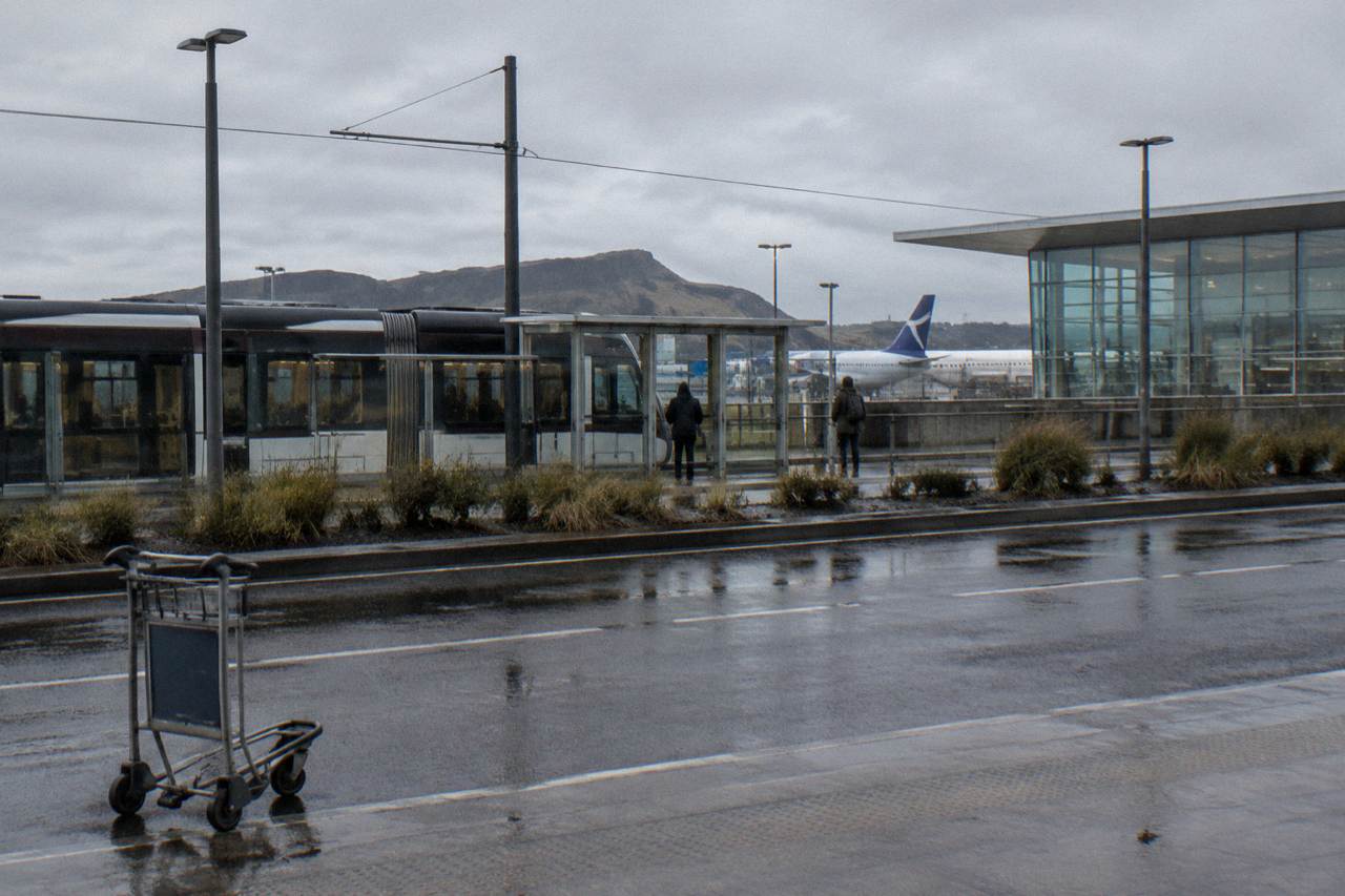 Edinburgh Airport terminal building under an overcast sky with planes at the gates