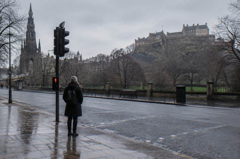 Winter view of Princes Street Gardens with the castle lit above bare trees