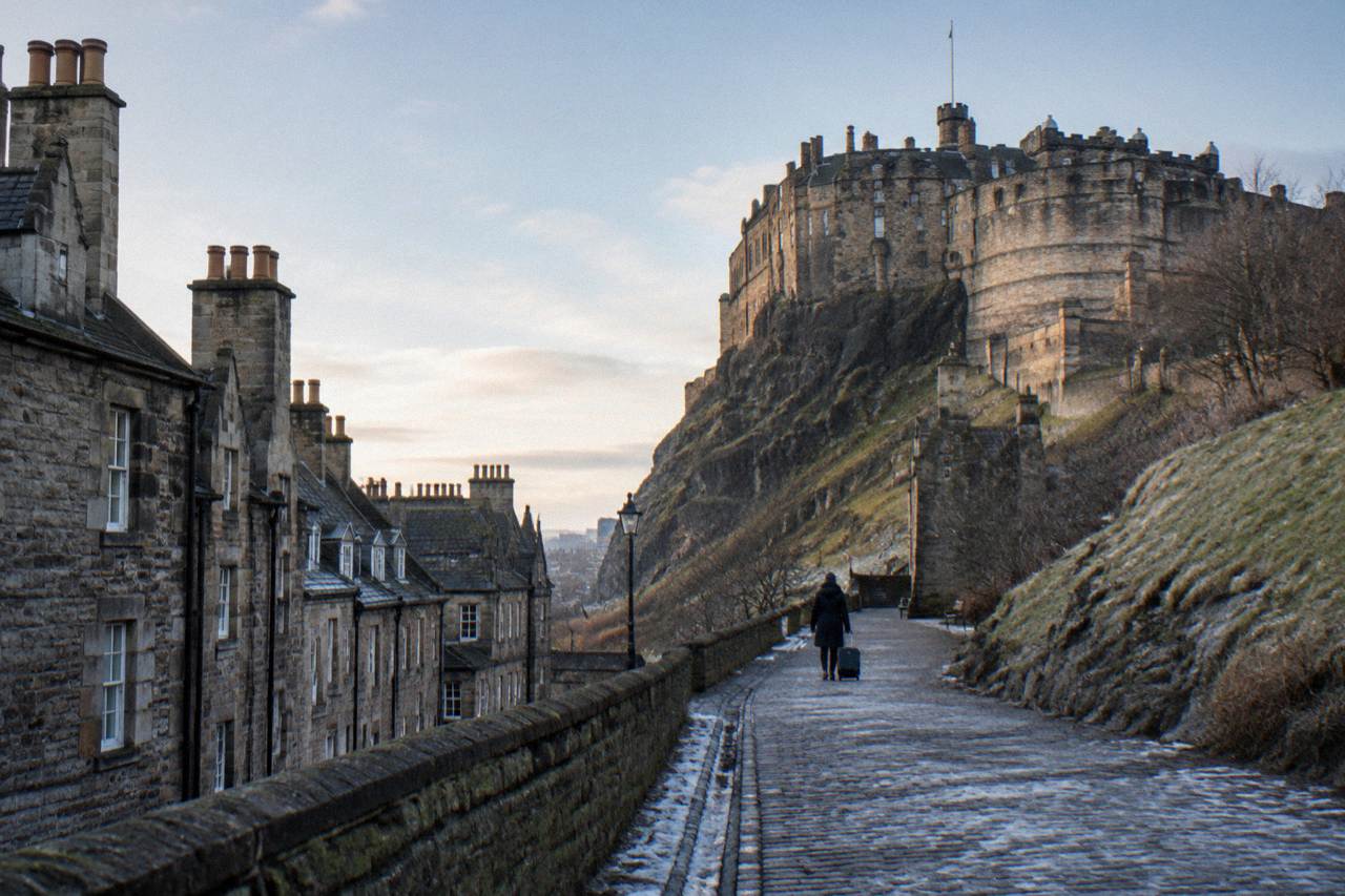 Georgian and Victorian buildings rising above rooftops toward Edinburgh Castle on its rocky crag