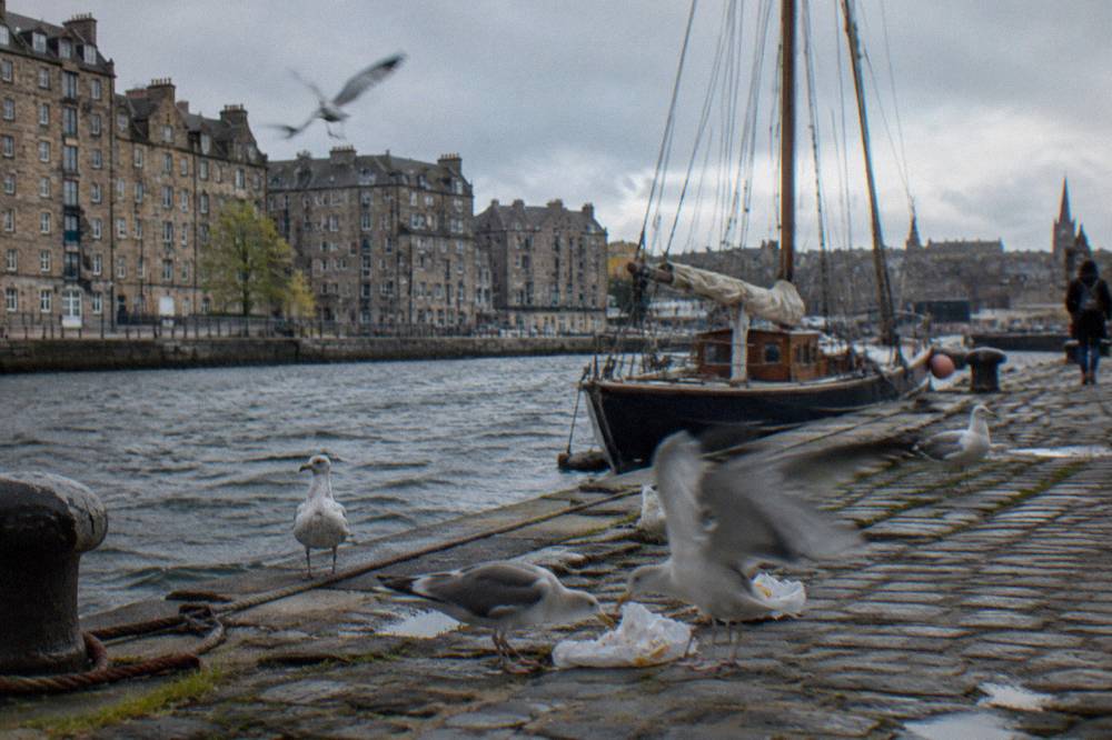 Waterfront buildings along the Shore in Leith with masted boats moored nearby