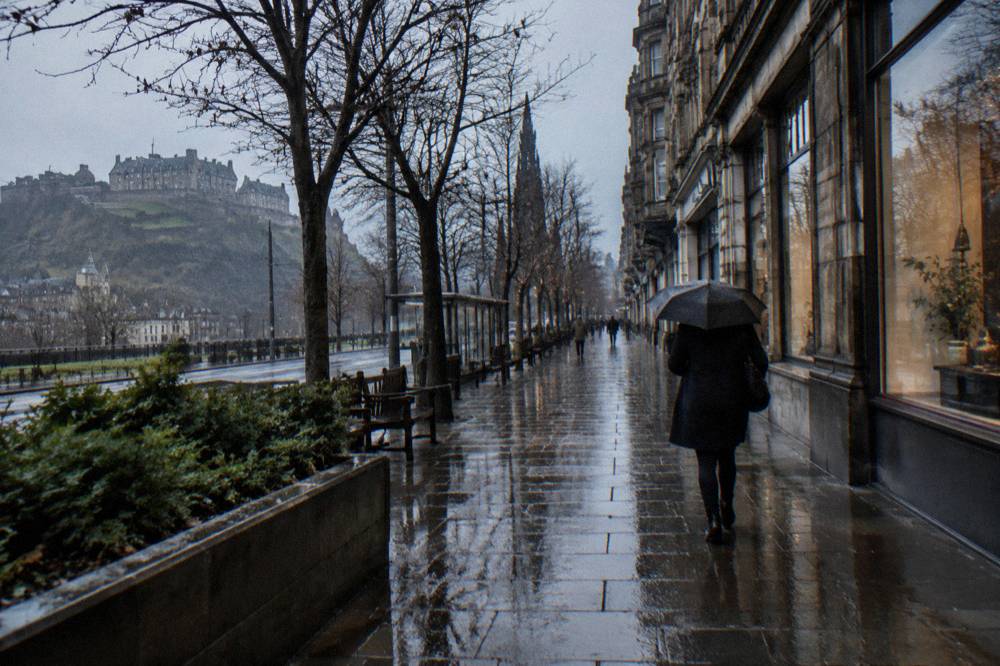 Rainy Princes Street in winter with hotel fronts along the terrace