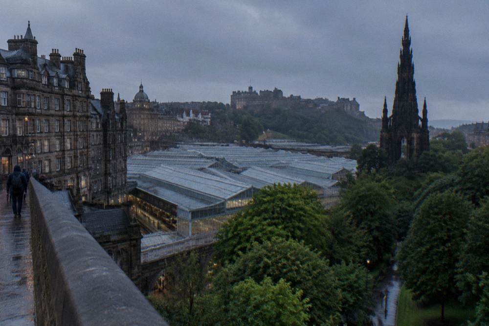 City view over Waverley station rooftops with Scott Monument and castle under a grey sky