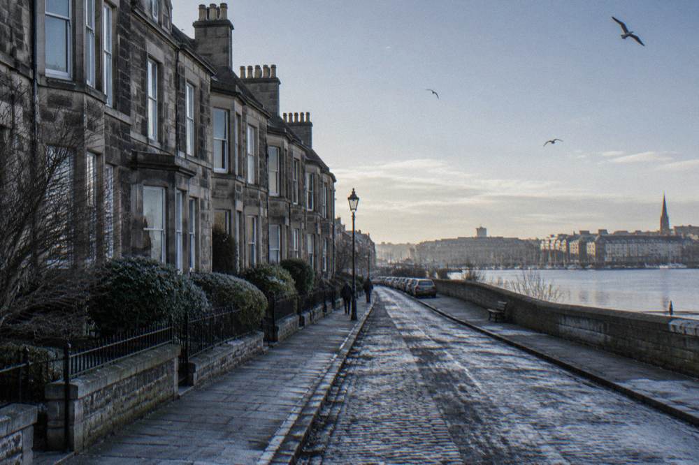 A quiet residential street of Victorian terraced houses in south Edinburgh with parked cars