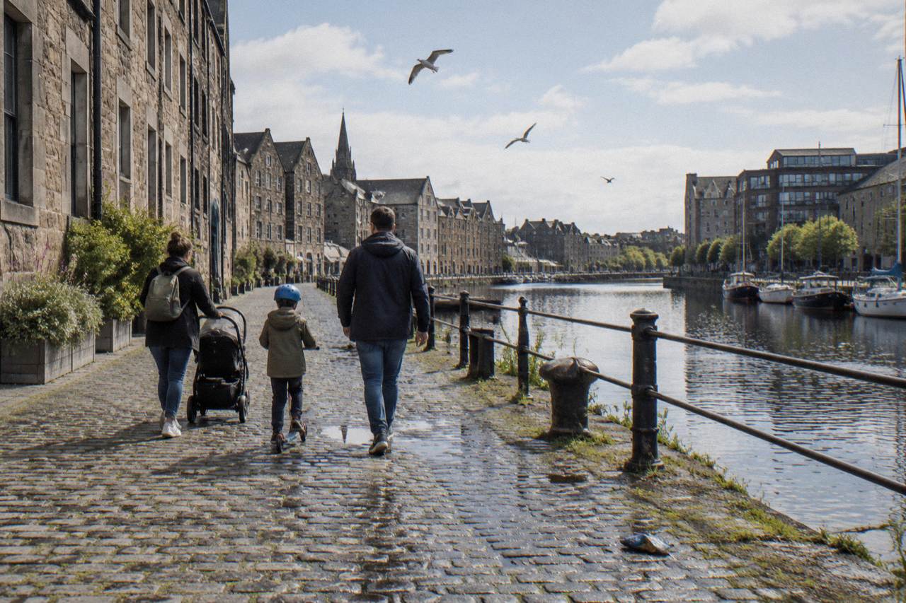Spacious family hotel room in Edinburgh with a double bed and child beds beside a window