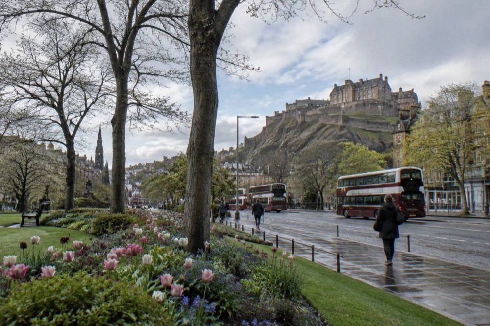 Princes Street in Edinburgh with the castle rising above gardens on the right