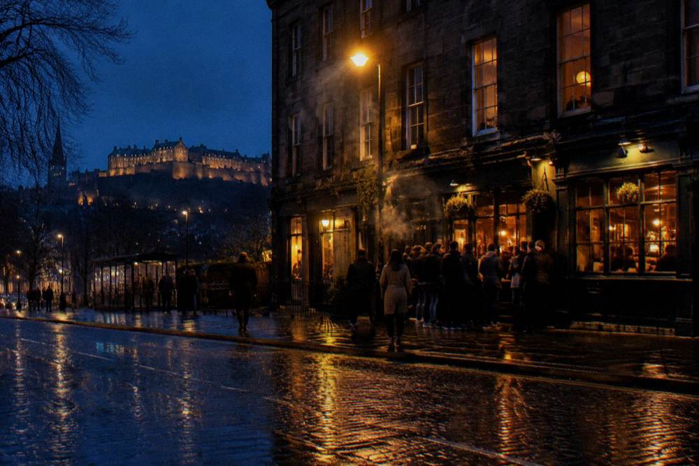 Night-lit Old Town street with pubs and people out in Edinburgh