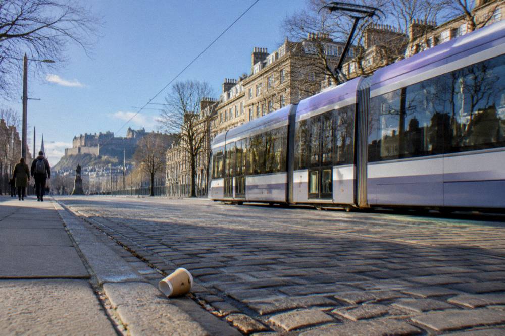 Tram on Princes Street with New Town buildings in Edinburgh
