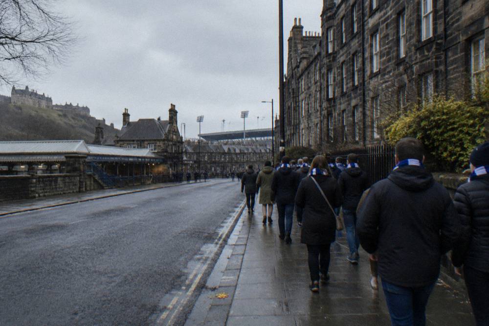 Crowds walking along a west Edinburgh street toward the stadium before an event
