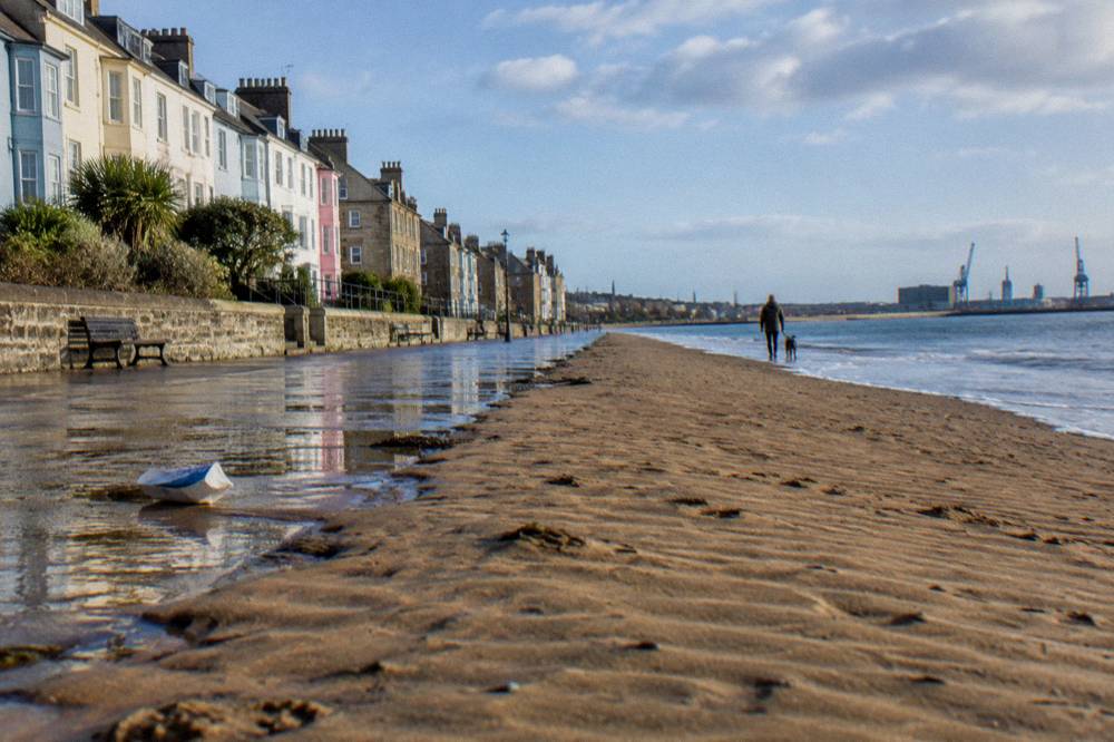 Victorian seaside promenade with wide sandy beach and painted frontage