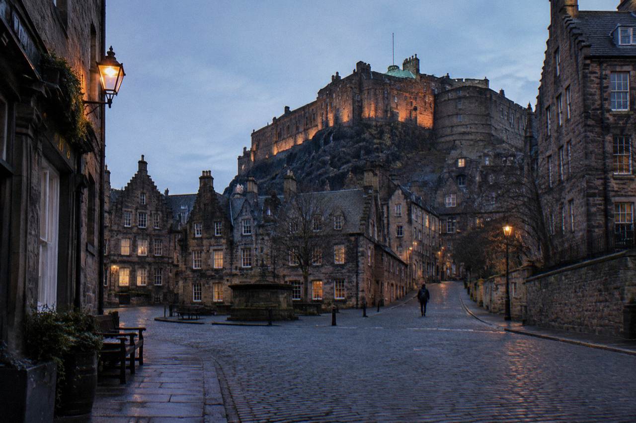 Edinburgh old town rooftops and castle seen from a quiet street at dusk